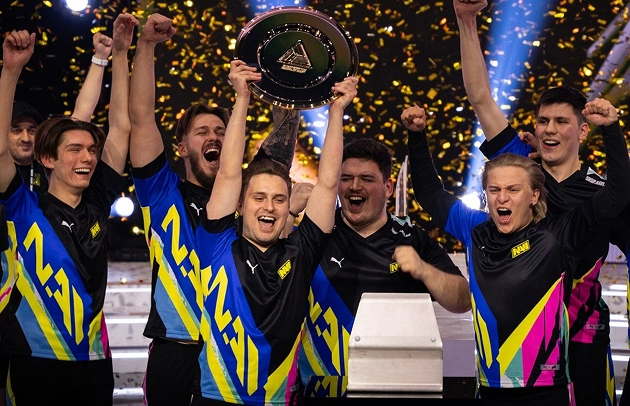 Het NAVI-team viert de overwinning met de trofee en confetti op het podium